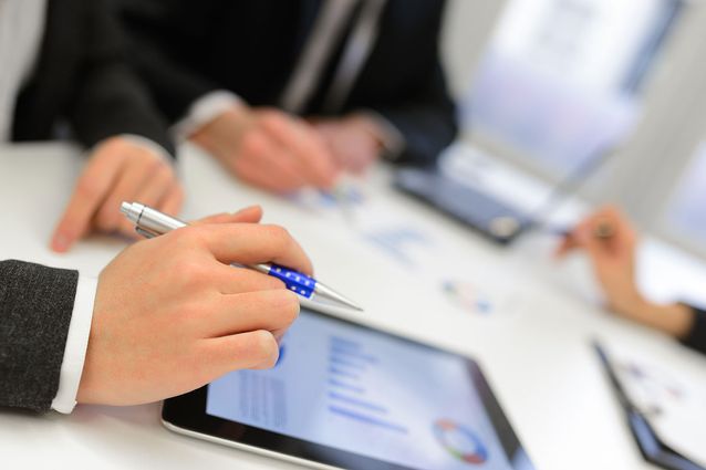 A group of business workers using software on mobile devices 